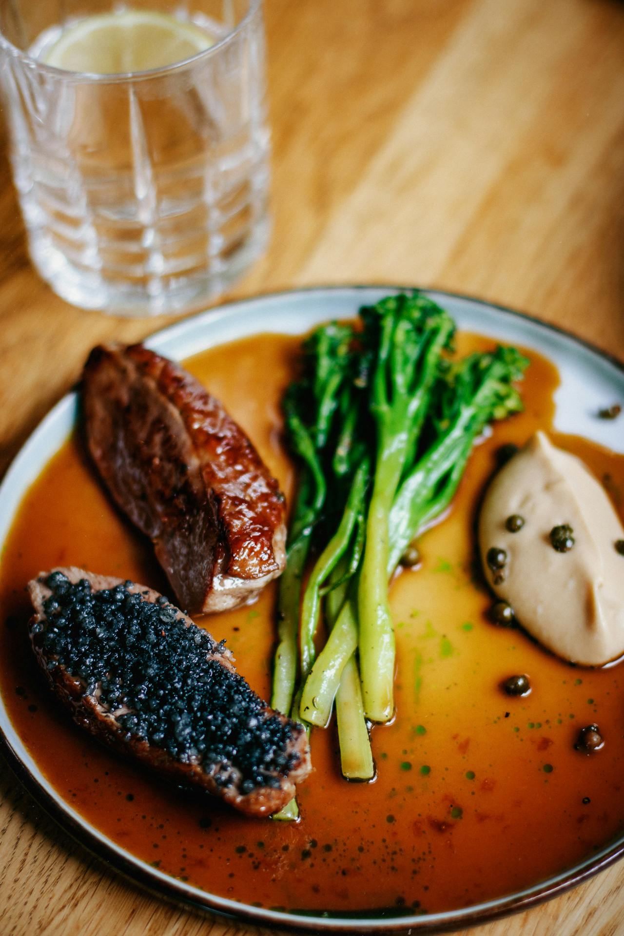 Dish with Broccolini Meat bread and dumplings topped with caviar